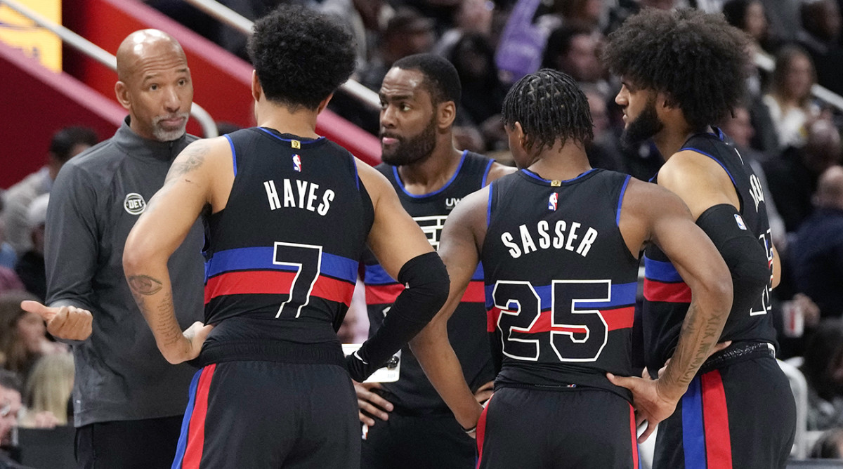 Pistons coach Monty Williams greets guard Cade Cunningham (2) and forward Isaiah Livers (12) as they come off the floor against the Pacers in the first quarter at Little Caesars Arena.